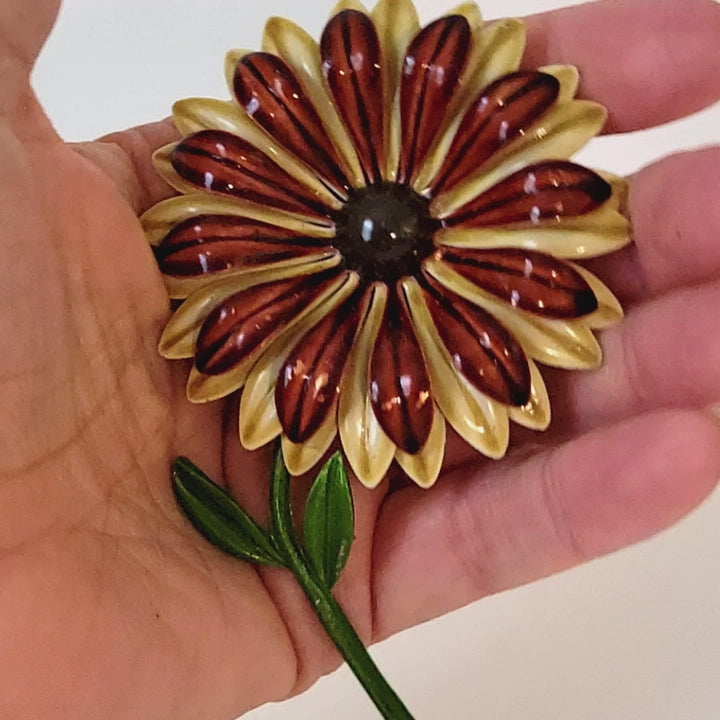 Large vintage enamel flower brooch in hand.