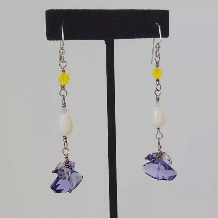 Video of long skinny purple and yellow, boho dangle earrings.