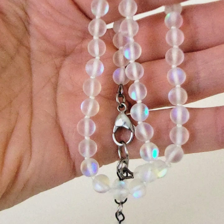 Rainbow frosted glass bead necklace in hand.