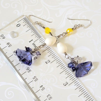 Yellow and purple crystal dangle earrings, next to a ruler.