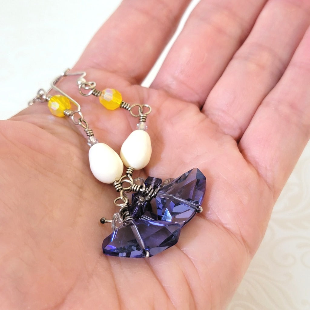 Handmade yellow and purple dangle earrings. Shown in hand, for size comparison.