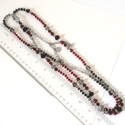 Long beaded necklace next to a ruler.