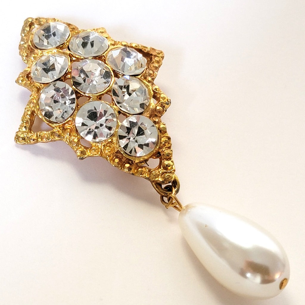 Rhinestone brooch with faux pearl dangle.