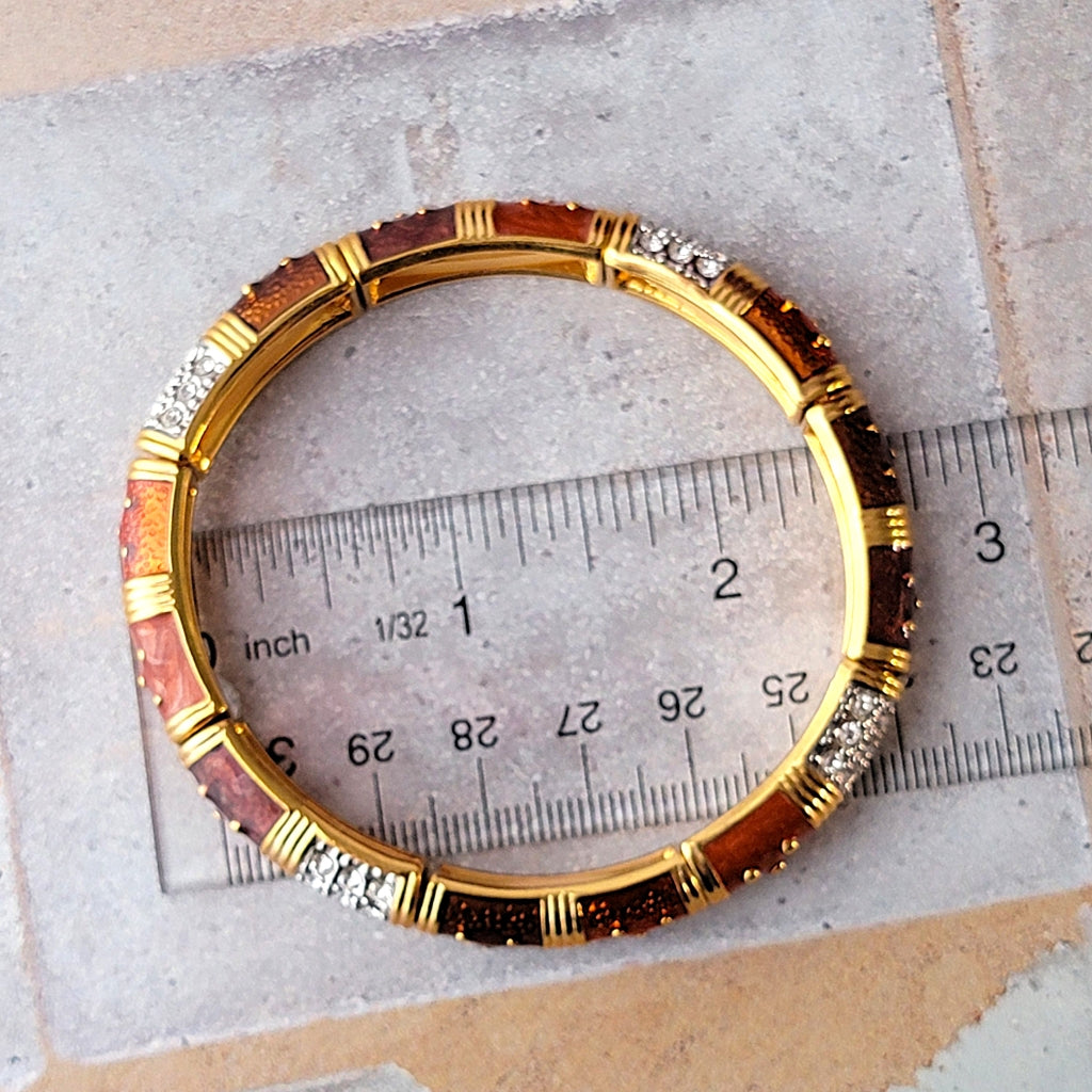 Gold tone stretch bracelet on a ruler.
