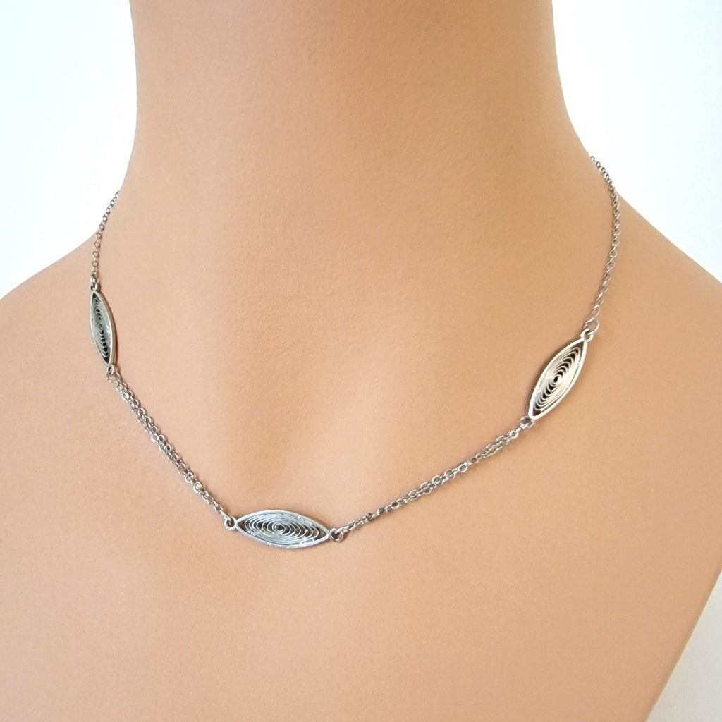Skinny silver tone choker on mannequin.