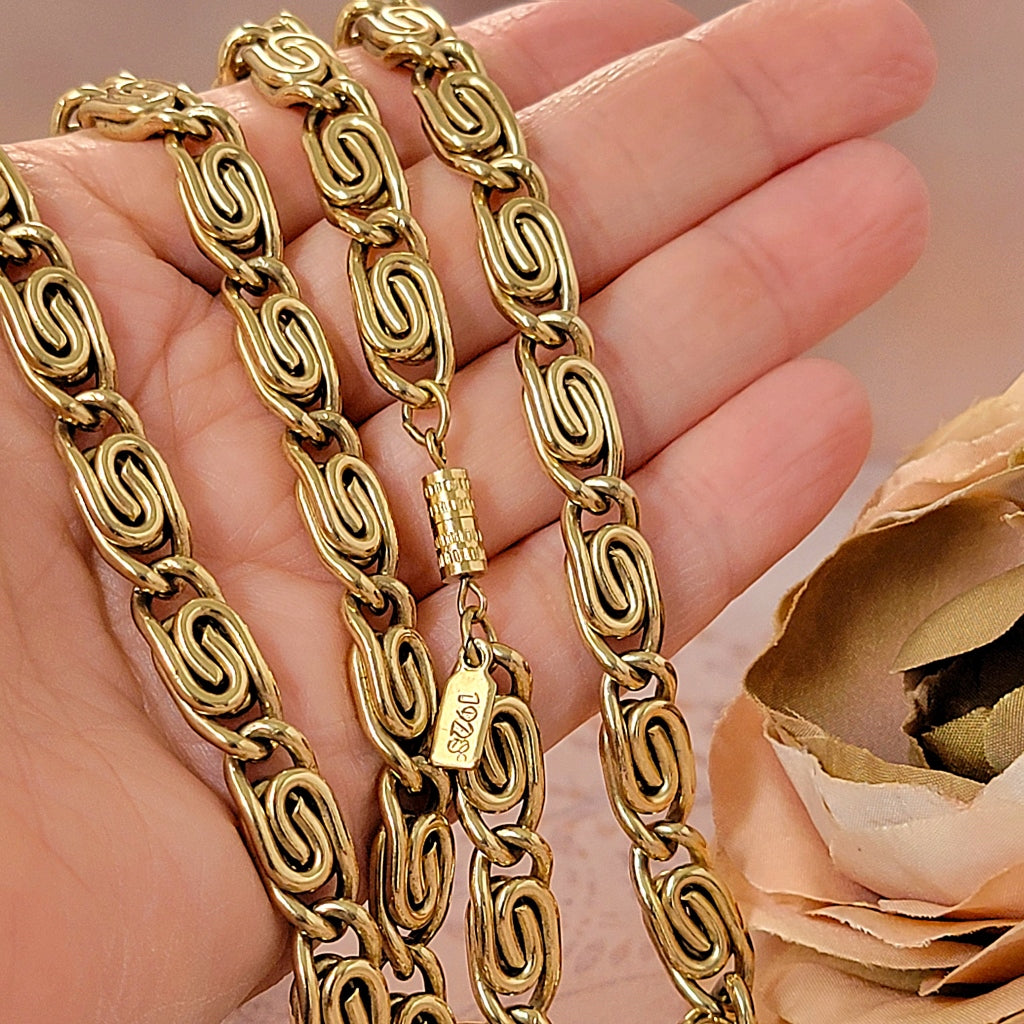 Thick gold tone snail chain in hand.