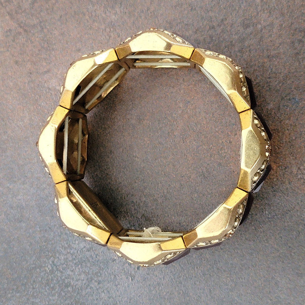 Top of a gold tone stretch bracelet.