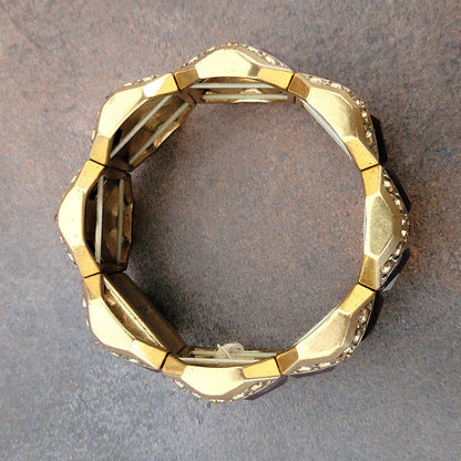 Top of a gold tone stretch bracelet.