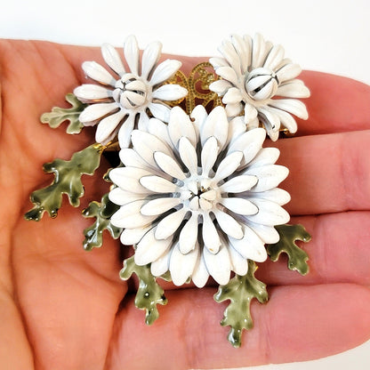 White flower pin in hand.