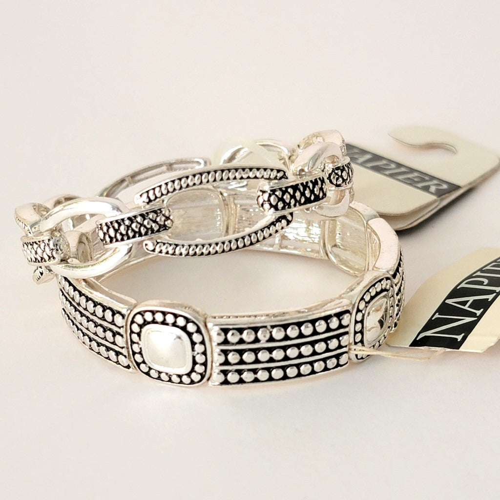 Two silver tone Napier bracelets.