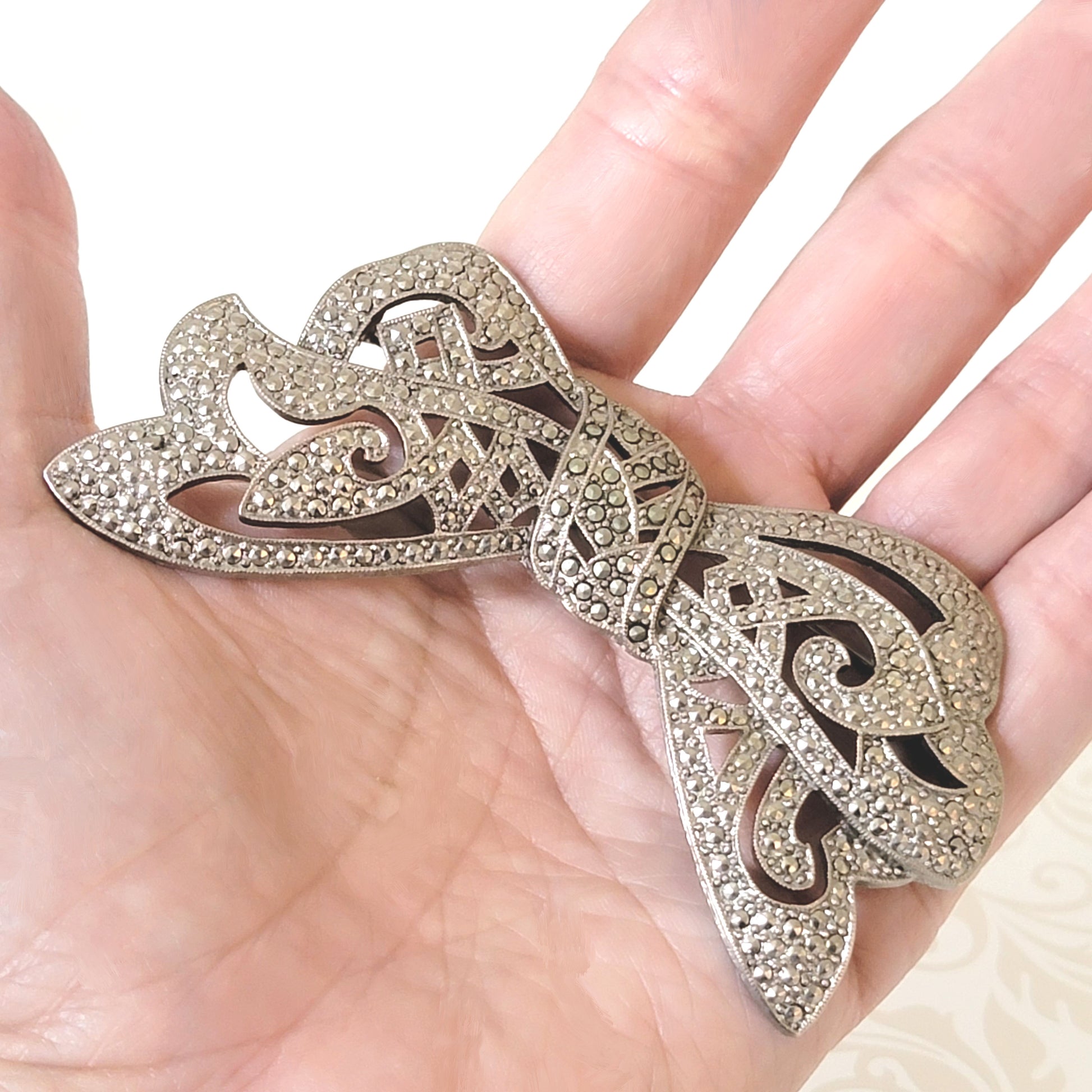 Vintage 1928 bow brooch in hand.