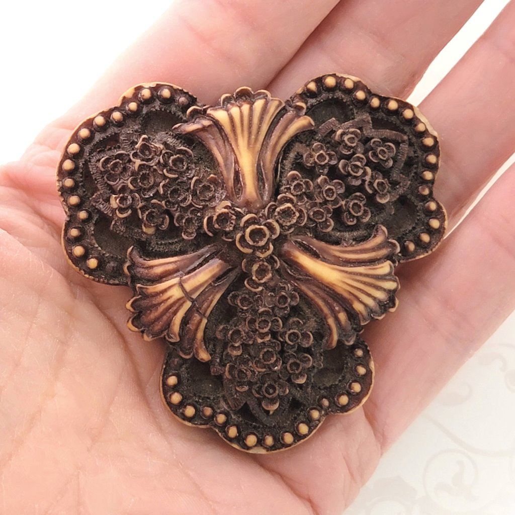 Vintage gothic floral brooch, chocolate color, with tiny flowers, shown in hand for size comparison.