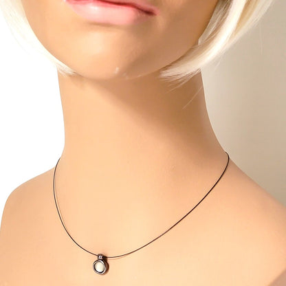 Express minimalist choker on a fine black cord, with small glass pendant. Shown on a mannequin.