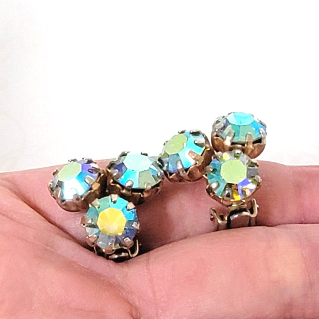 Weiss three rhinestone clip-on earrings, shown in hand, for size comparison.