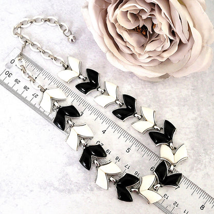 Vintage black and white thermoset necklace next to a ruler.