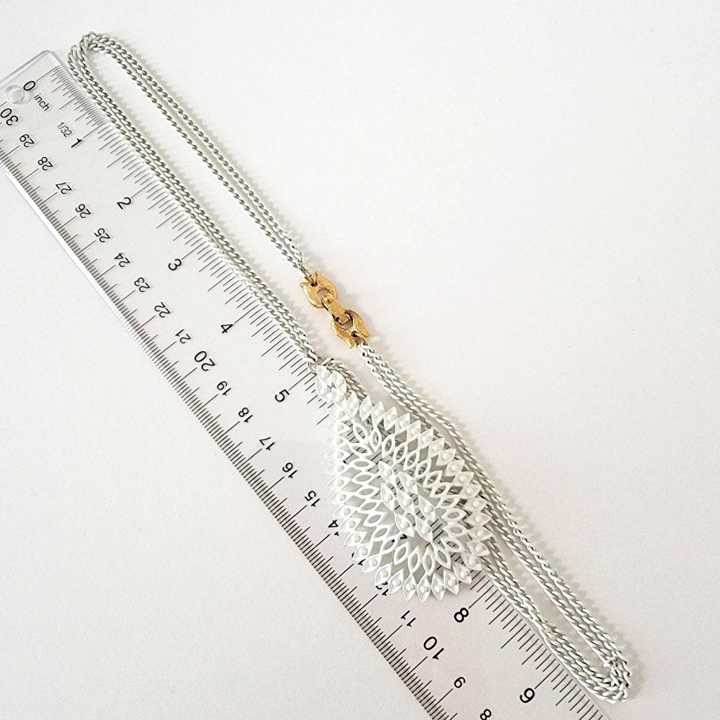 White necklace with ruler.