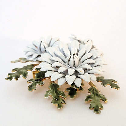 Layers of a white vintage enamel flower brooch.