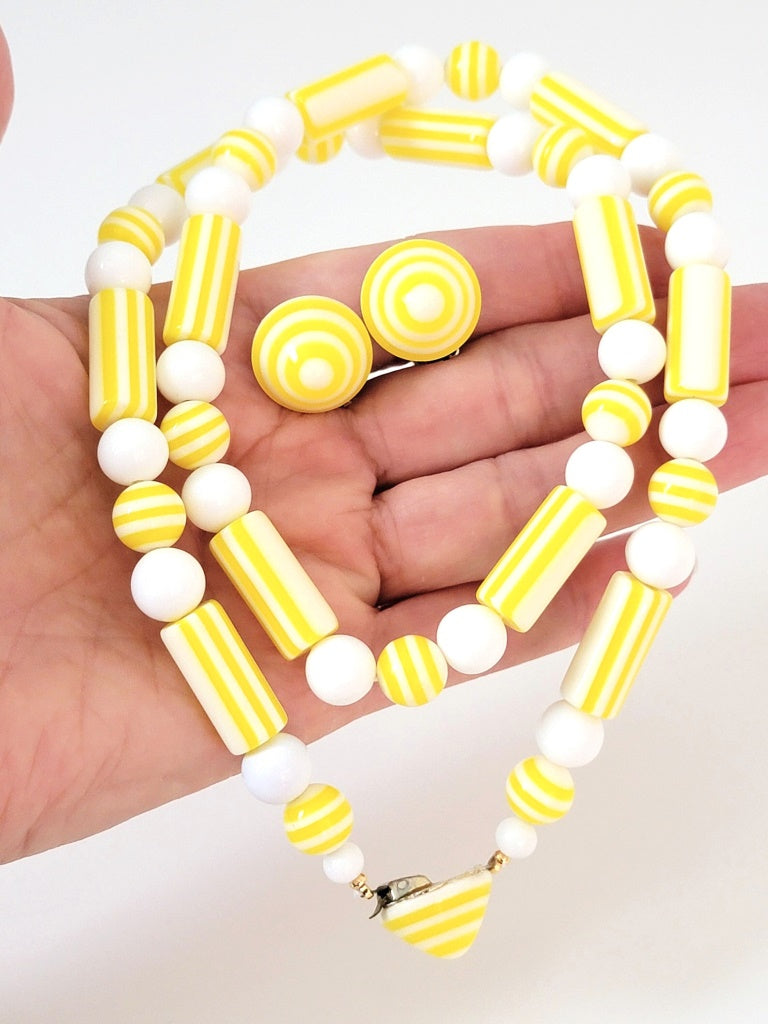 Yellow earrings and necklace in hand.
