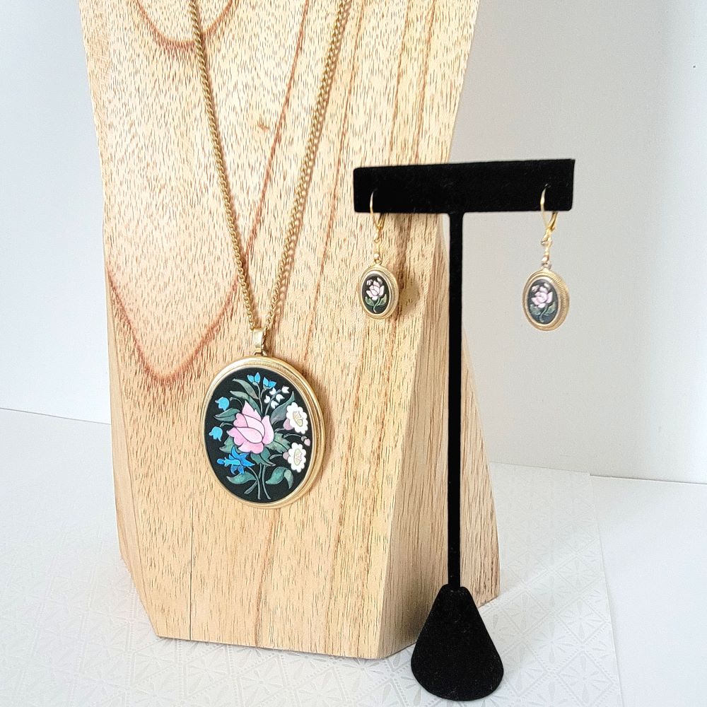 Avon floral necklace and earrings, shown on display stands.