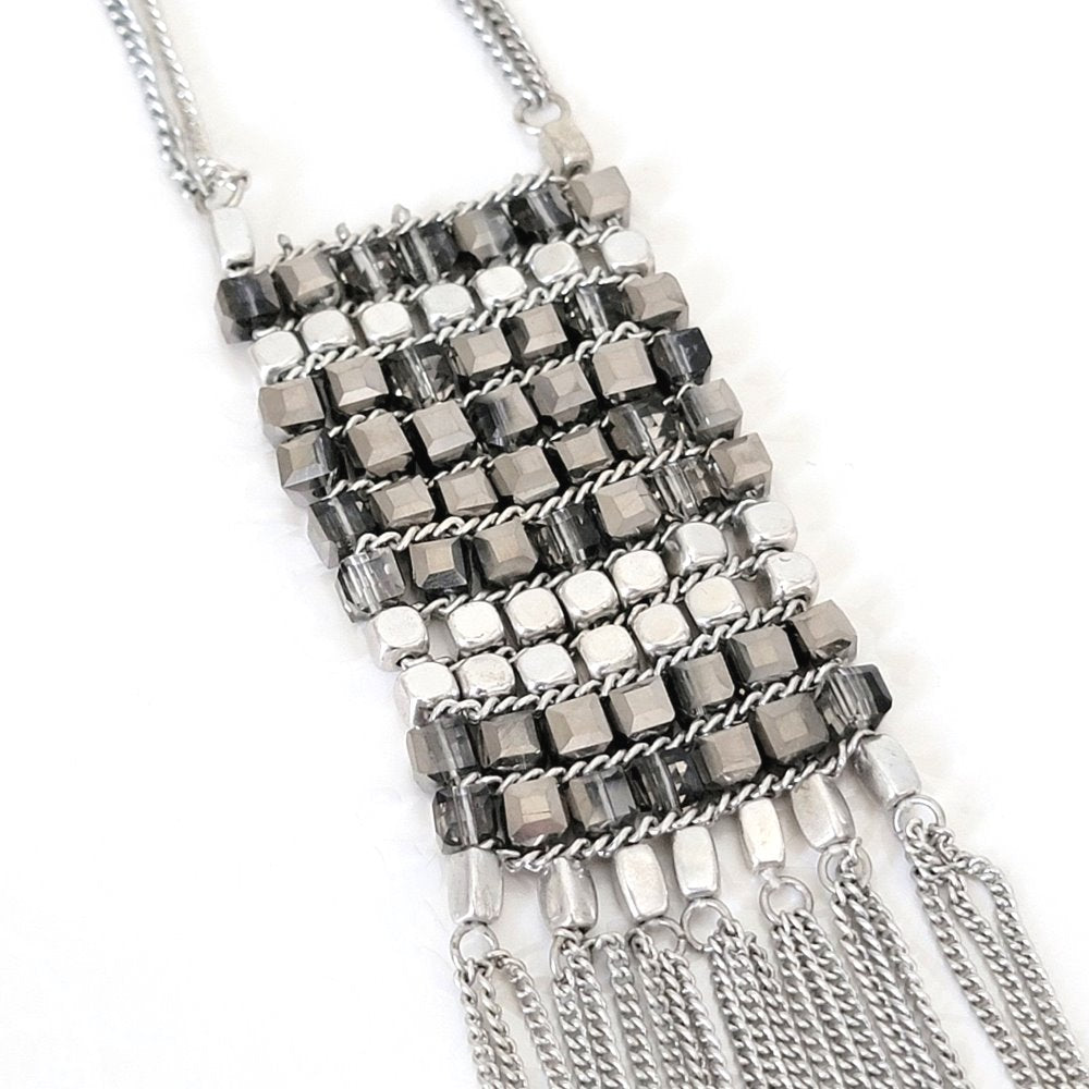 Closeup view of cube beaded pendant on a Kenneth Cole necklace.