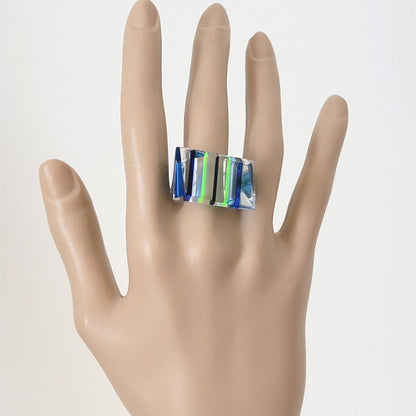 Mod blue and neon yellow striped acrylic ring on hand.
