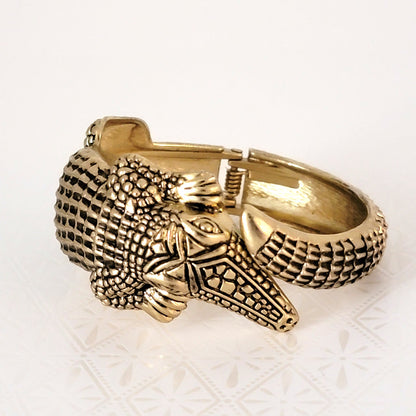 Alligator hinged clamper bracelet in antique gold tone, with black details