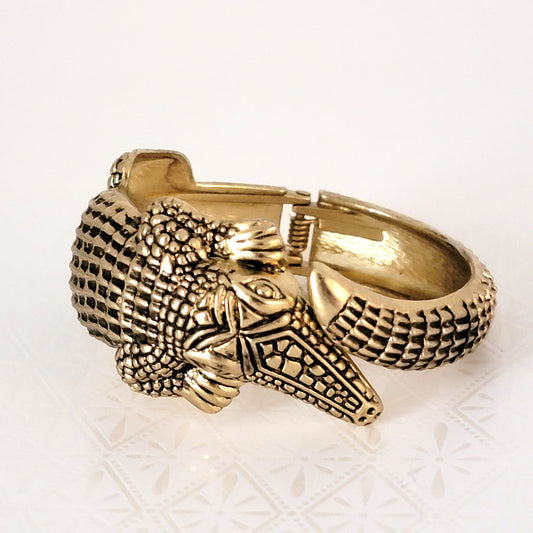 Alligator hinged clamper bracelet in antique gold tone, with black details