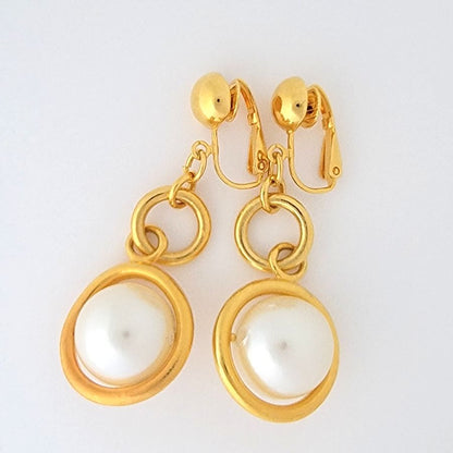 Avon faux pearl clip earrings, with gold tone circular rings.