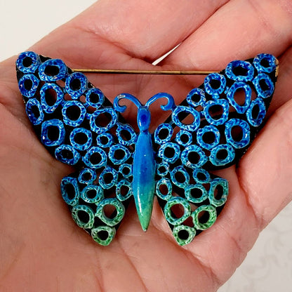 Vintage blue enamel butterfly pin, with mod circle design. Shown in hand, for size comparison.