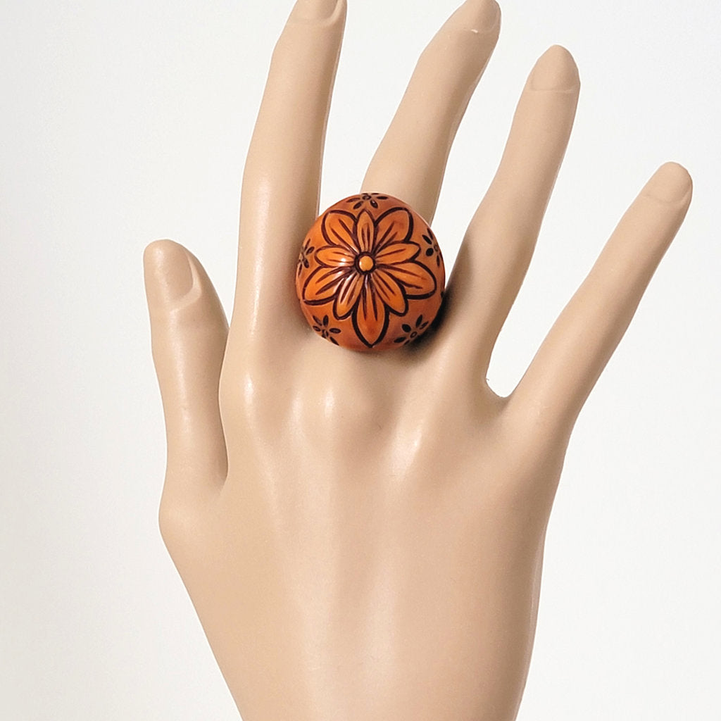 Chunky, boho, orangey brown plastic flower ring, on hand.