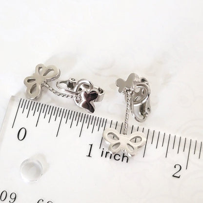 Crown Trifari butterfly earrings, next to a ruler.