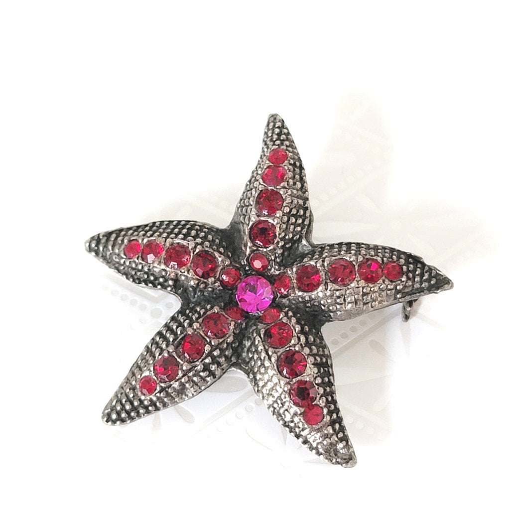 Red and pink rhinestone starfish brooch, in antique silver tone, by D. Pollak.