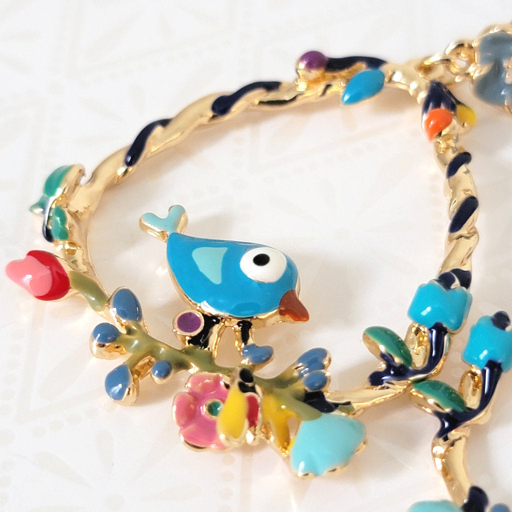 Closeup view of enamel blue bird earrings.