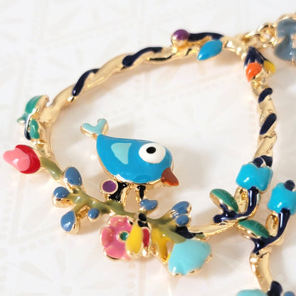Closeup view of enamel blue bird earrings.