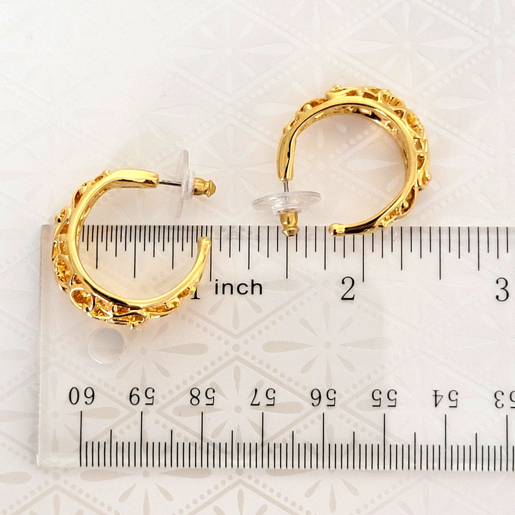 gold tone filigree hoop earrings next to a ruler