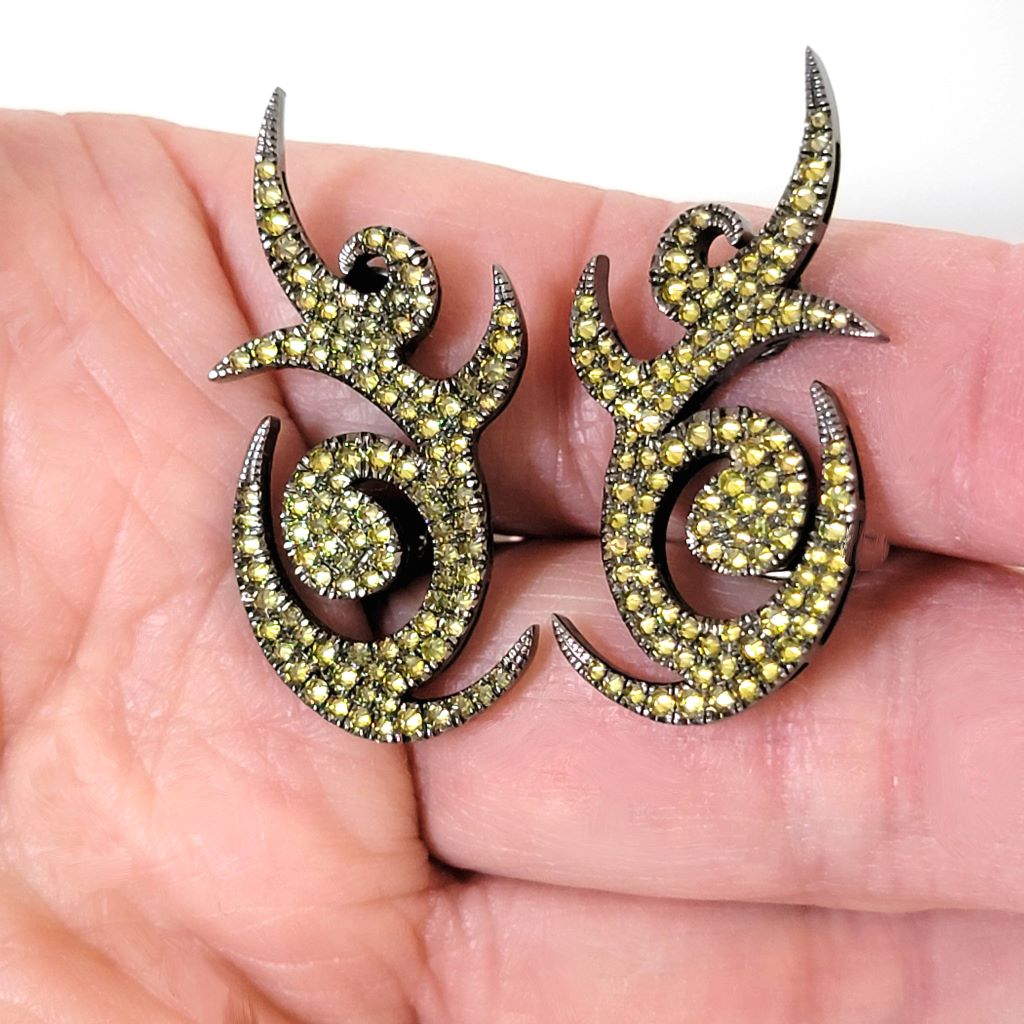 Curvy spikes yellow pave rhinestone clip earrings, shown in hand, for size comparison.