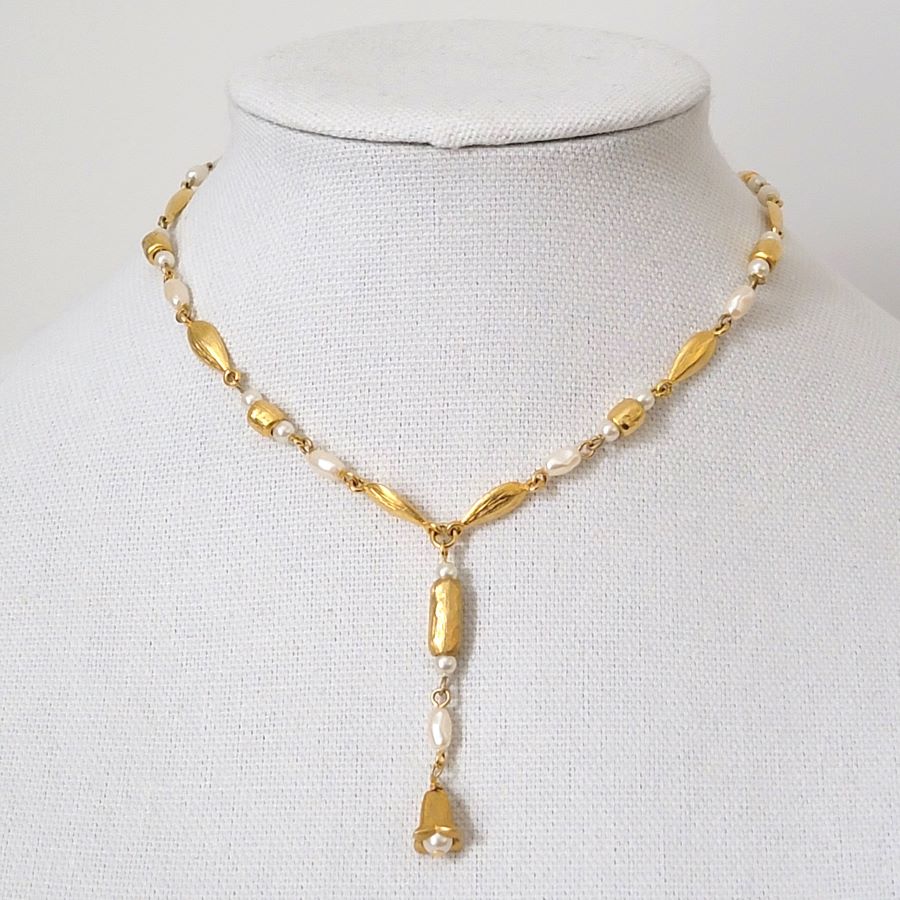 Liz Claiborne faux pearl and gold tone lavalier style choker necklace on display stand.