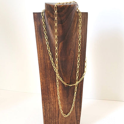 Long gold tone Monet chain necklace, double wrapped on a display stand.