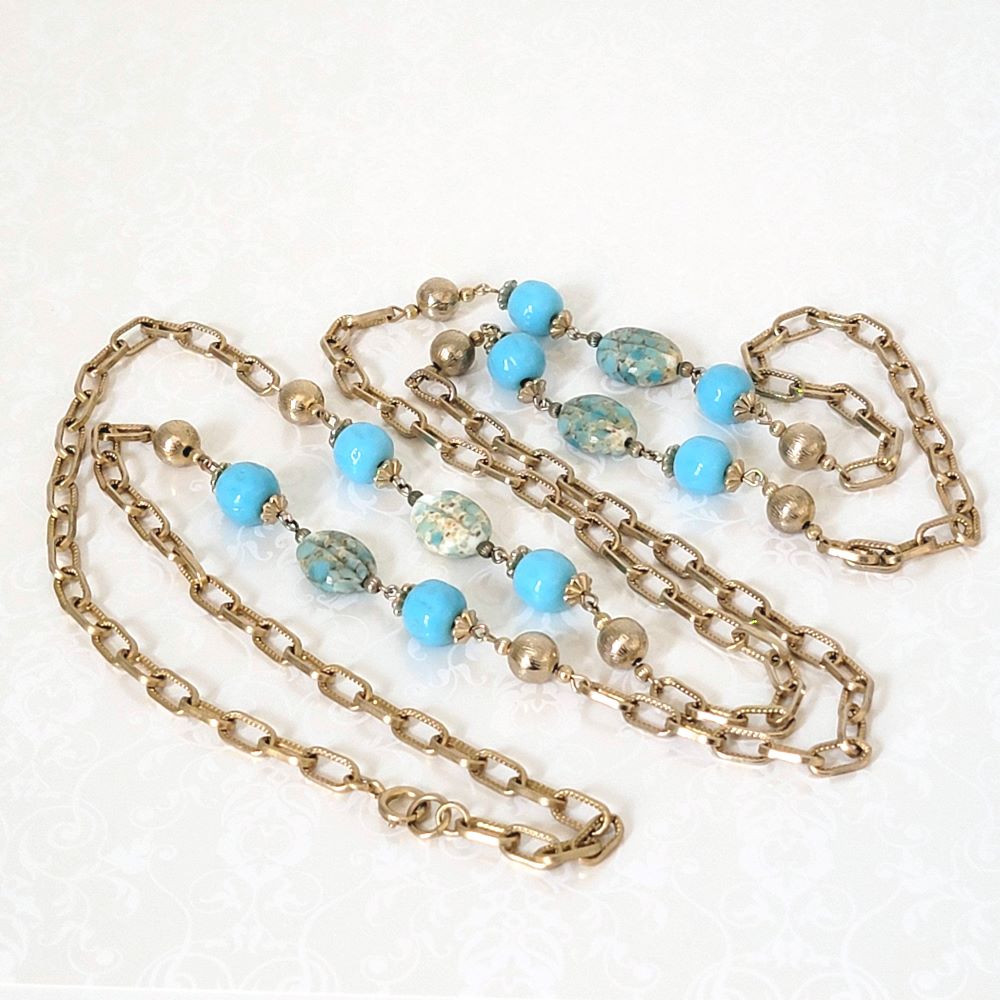 Station style, vintage long gold tone chain necklace with turquoise blue glass beads.