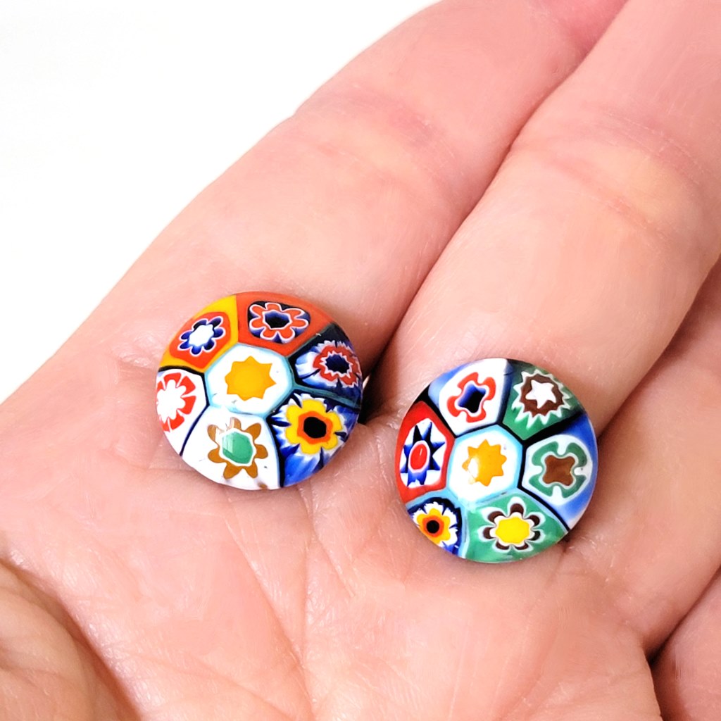 Multicolor vintage millefiori glass clip-on earrings, shown in hand, for size comparison.