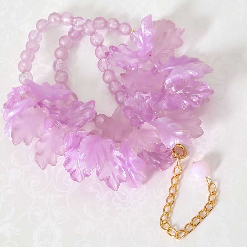 Light purple plastic leaves beaded necklace, with gold tone extender chain.