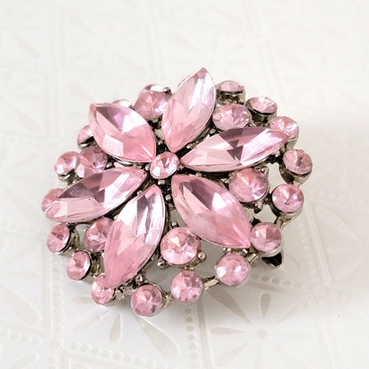 Pastel pink 80s rhinestone brooch, with a floral pattern.