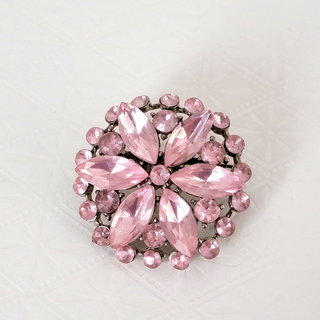 Pastel pink acrylic rhinestone cluster brooch, with a flower design.