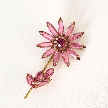 pink rhinestone flower brooch, with long skinny petals, and gold tone stem