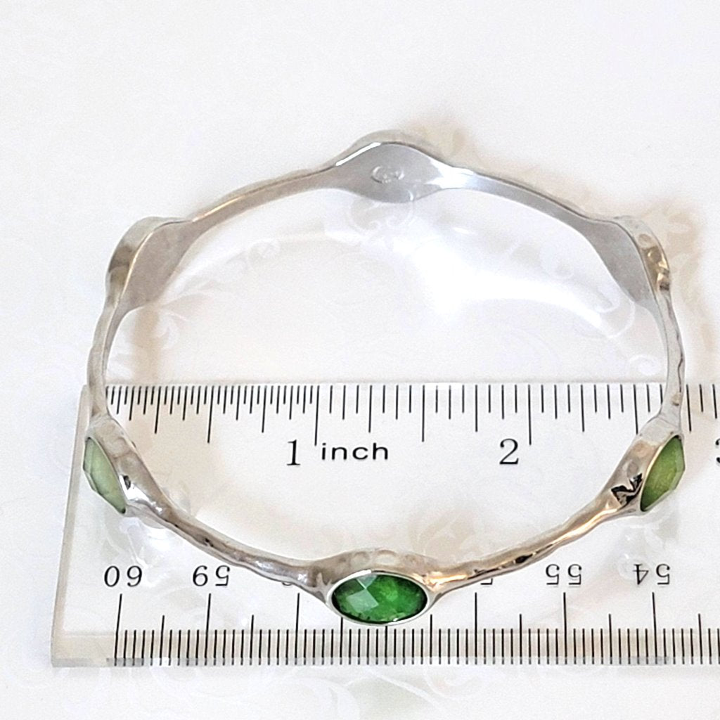 Premier Designs skinny silver tone bangle bracelet, shown next to a ruler.