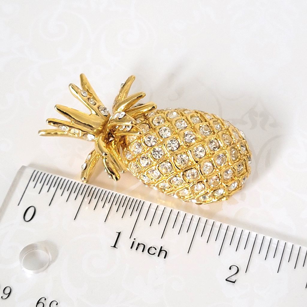 Rhinestone pineapple brooch, shown next to a ruler.