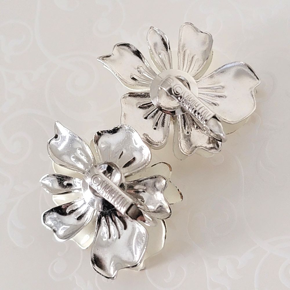 Back view of Sarah Coventry flower clip earrings, showing logo signature marks.