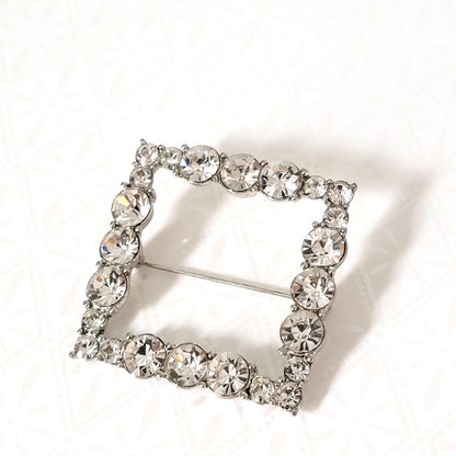 Square shaped rhinestone pendant or brooch, set in silver tone.