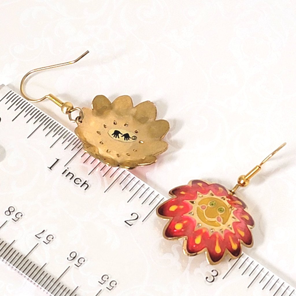Two Hands brand smiley happy sunflower earrings, shown next to a ruler.