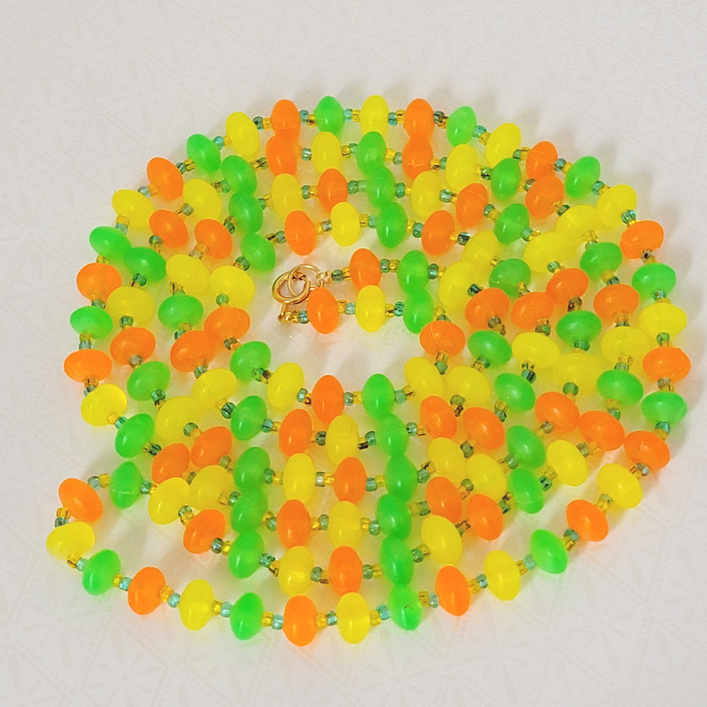 Long 60s, hippie style plastic beaded necklace, in bright orange, yellow and green.